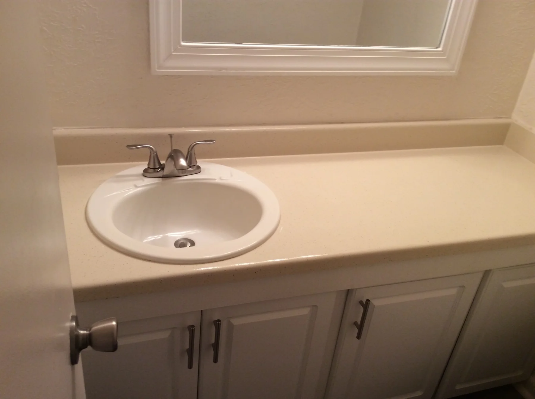 Single-sink apartment bathroom countertop before refinishing