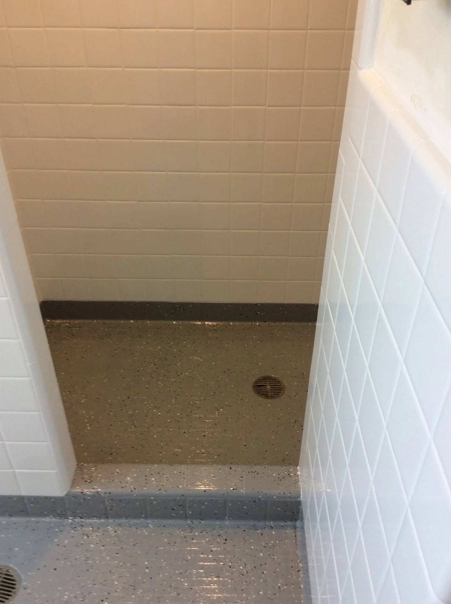Renewed dormitory shower tile and floor after refinishing