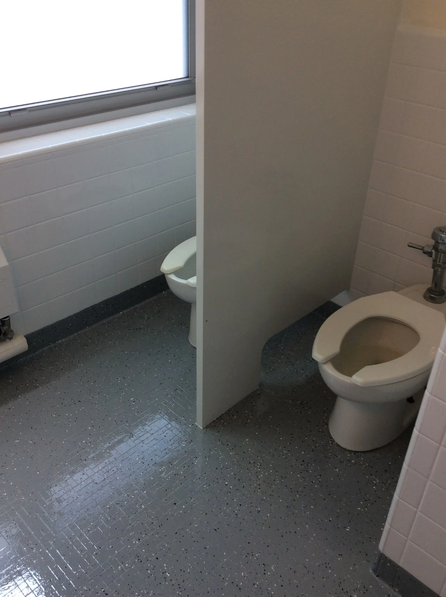 Dormitory restroom partitions, tile walls, and floor after refinishing