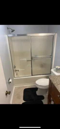 Dated bathtub and shower enclosure before refinishing