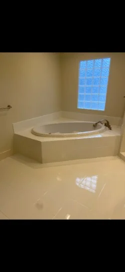 Bright corner bathtub deck and unified floor after resurfacing