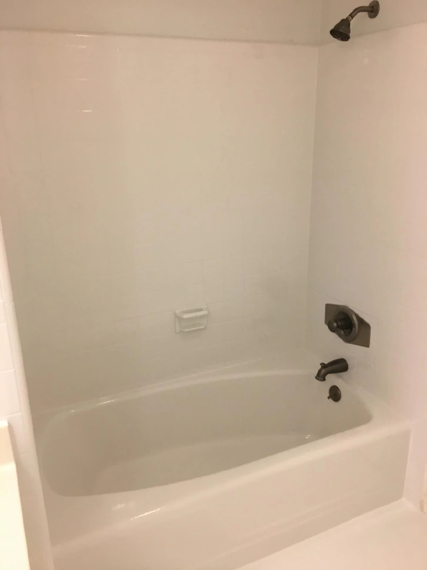Bright restored bathtub and wall surfaces after professional refinishing