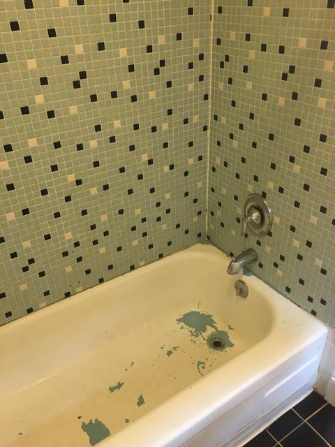 Worn bathtub before professional refinishing