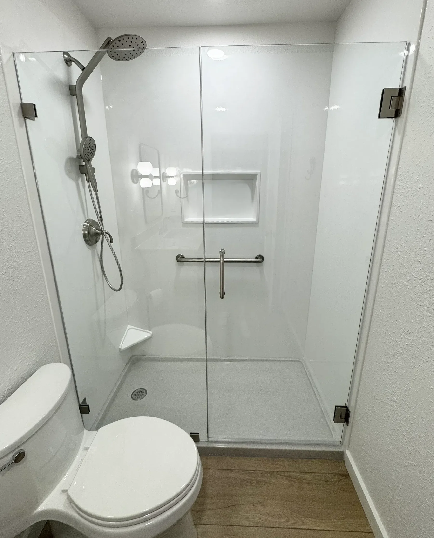 Completed shower with glass enclosure and handheld shower fixture