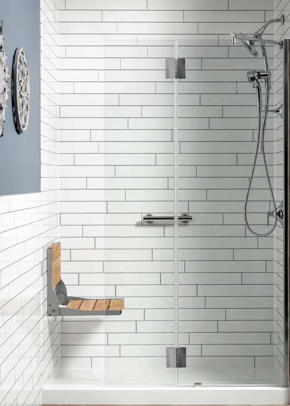 Bright subway-look shower with glass door, fold-down seat, handheld shower, and grab bar