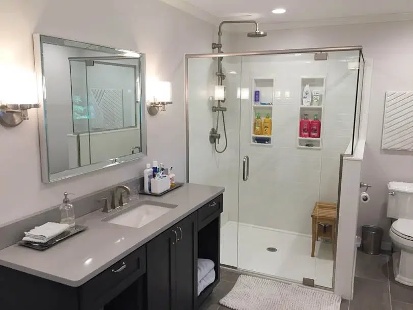 Completed bathroom remodel with vanity, glass shower, and toilet